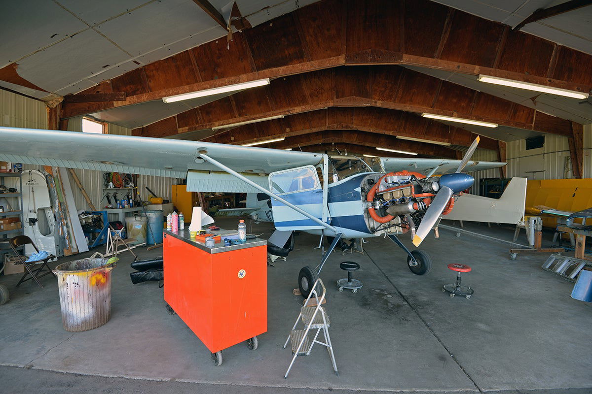 Single engine airplane undergoing an inspection in a hangar