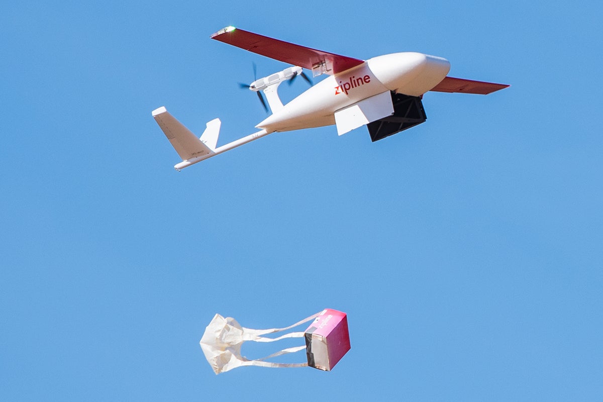 Airborne Zipline drone drops package with parachute