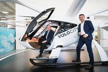 Singapore and Volocopter officials pose in a VoloCity prototype eVTOL air taxi