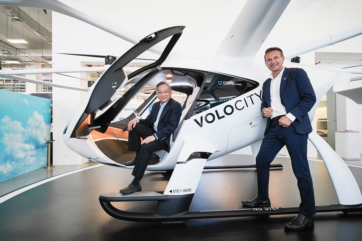 Singapore and Volocopter officials pose in a VoloCity prototype eVTOL air taxi