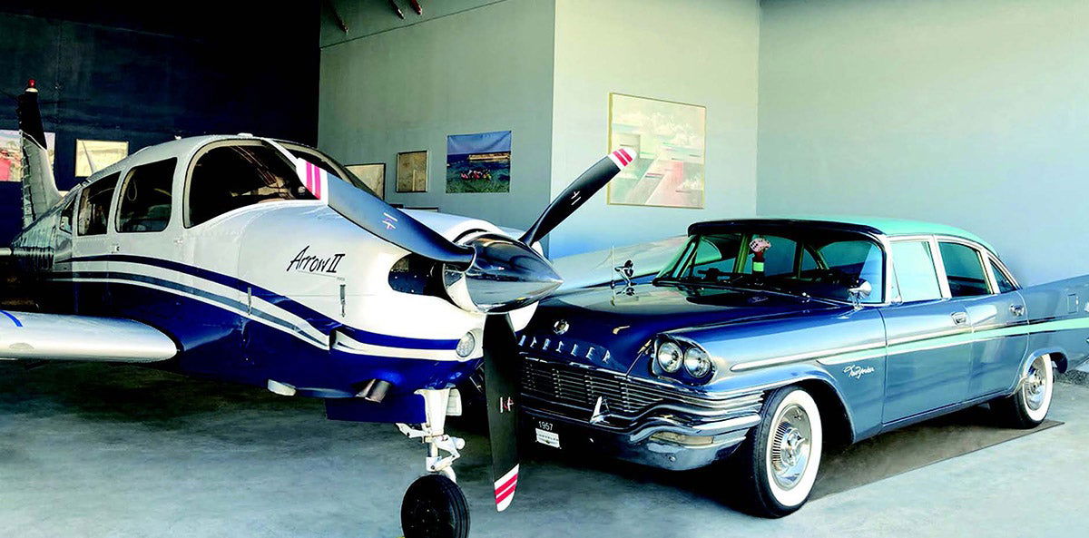 A Piper and a Chrysler sitting next to each other in a hangar