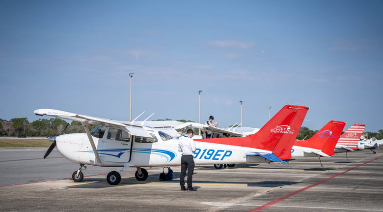 a piston aircraft sits on an airport ramp